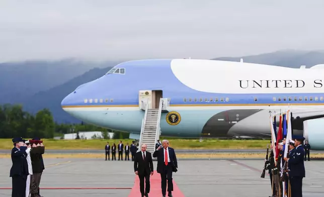 President Donald Trump salutes as he walks Russia's President Vladimir Putin, Friday, Aug. 15, 2025, at Joint Base Elmendorf-Richardson, Alaska. (AP Photo/Julia Demaree Nikhinson)
