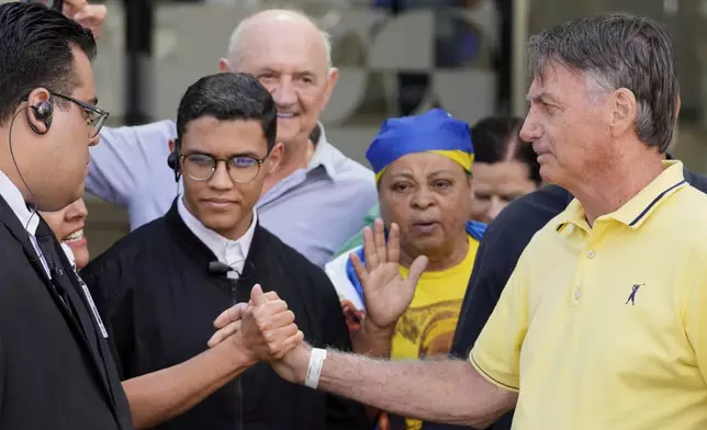 Brazil’s former President Jair Bolsonaro, right, temporarily allowed out of house arrest for medical exams, departs a hospital in Brasília, Brazil, Saturday, Aug. 16, 2025. (AP Photo/Eraldo Peres)