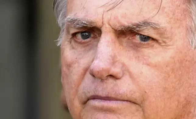 Brazil’s former President Jair Bolsonaro, center, temporarily allowed out of house arrest for medical exams, departs a hospital in Brasília, Brazil, Saturday, Aug. 16, 2025. (AP Photo/Eraldo Peres)