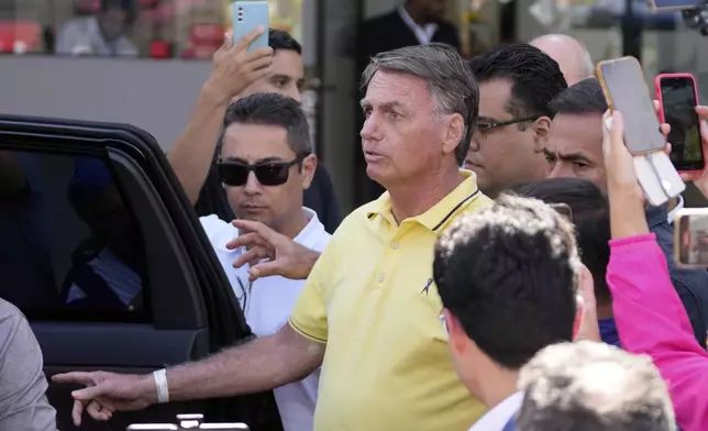 Brazil’s former President Jair Bolsonaro, center, temporarily allowed out of house arrest for medical exams, departs a hospital in Brasília, Brazil, Saturday, Aug. 16, 2025. (AP Photo/Eraldo Peres)