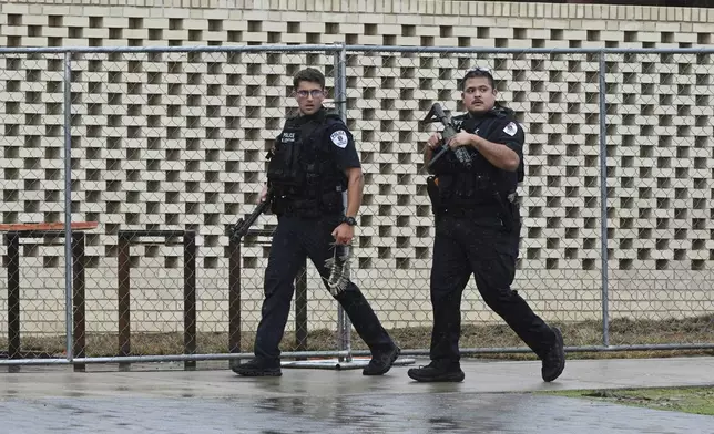 Law enforcement officers respond to reports of a shooting on the University of Arkansas campus Monday, Aug. 25, 2025, in Fayetteville, Ark. (AP Photo/Michael Woods)