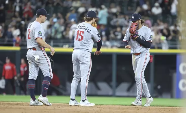 Minnesota Twins shortstop Brooks Lee (2), second baseman Luke Keaschall (15) and outfielder Austin Martin, right, celebrate after their team's win over the Chicago White Sox in a baseball game, Friday, Aug. 22, 2025, in Chicago. (AP Photo/Talia Sprague)