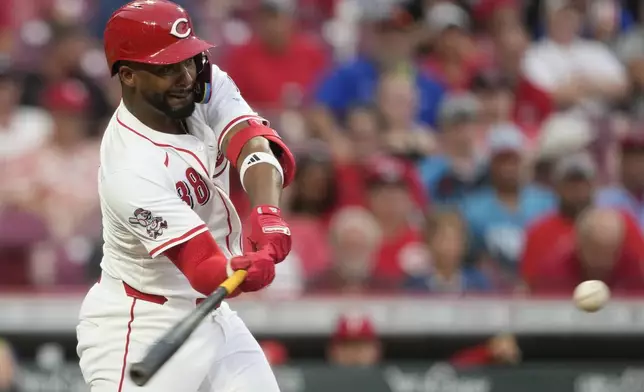 Cincinnati Reds designated hitter Miguel Andujar hits a solo home run during the fourth inning of a baseball game against the Philadelphia Phillies Tuesday, Aug. 12, 2025, in Cincinnati. (AP Photo/Carolyn Kaster)