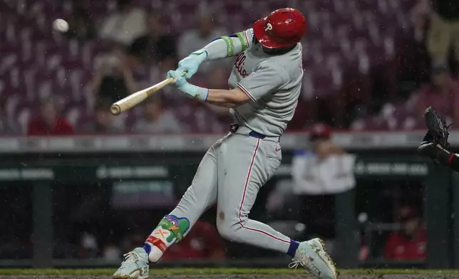 Philadelphia Phillies' Bryce Harper hits a solo home run during the ninth inning of a baseball game against the Cincinnati Reds Tuesday, Aug. 12, 2025, in Cincinnati. (AP Photo/Carolyn Kaster)