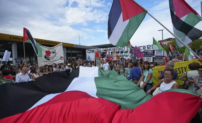 Demonstrators hold Palestinian flags during a march in support of the Palestinian people in Gaza, during the Film Festival in Venice, Italy, Saturday, Aug. 30, 2025. (Photo by Alessandra Tarantino/Invision/AP)