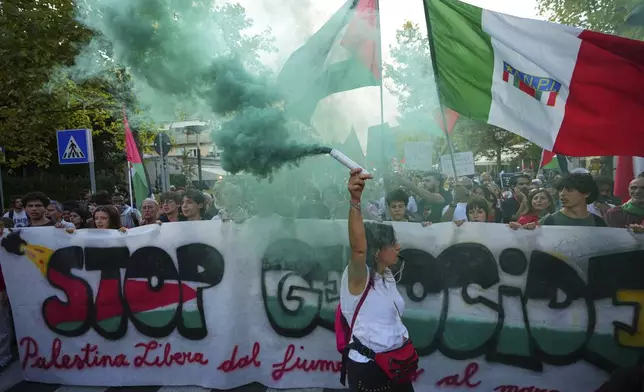 Demonstrators hold a banner that reads 'Stop Genocide' during a march in support of the Palestinian people in Gaza, during the Film Festival in Venice, Italy, Saturday, Aug. 30, 2025. (Photo by Alessandra Tarantino/Invision/AP)