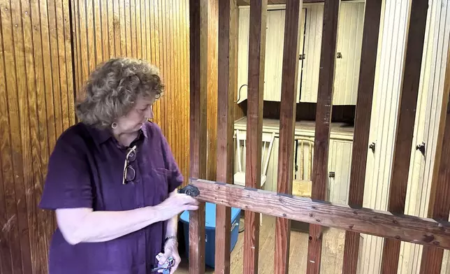 Local historian Sue Hostetter opens the door to the rarely used jail cell with wooden bars on the second floor of the Hall of Philosophy, Wednesday, Aug. 6, 2025, in Mount Gretna, Pa. (AP Photo/Mark Scolforo)