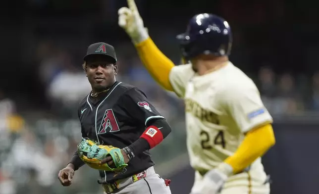 Arizona Diamondbacks' Geraldo Perdomo, left, talks with Milwaukee Brewers' William Contreras (24) during the fourth inning of a baseball game Monday, Aug. 25, 2025, in Milwaukee. (AP Photo/Aaron Gash)