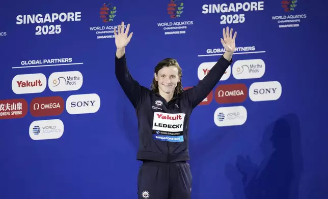 Gold medalist Katie Ledecky of the United States celebrates on the podium after the women's 800-meter freestyle final at the World Aquatics Championships in Singapore, Saturday, Aug. 2, 2025. (AP Photo/Lee Jin-man)