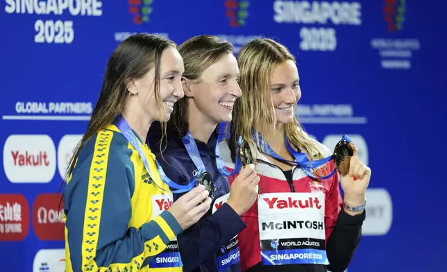 Gold medalist Katie Ledecky of the United States, center, flanked by silver medalist Lani Pallister of Australia, left, and bronze medalist Summer McIntosh of Canada pose on the podium after the women's 800-meter freestyle final at the World Aquatics Championships in Singapore, Saturday, Aug. 2, 2025. (AP Photo/Vincent Thian)