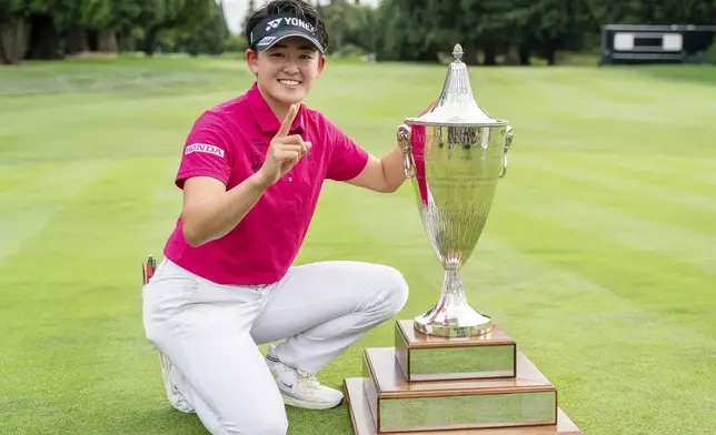 Akie Iwai, of Japan, poses with the trophy after winning the LPGA Portland Classic golf tournament at Columbia Edgewater in Portland, Ore., Sunday, Aug. 17, 2025. (AP Photo/Ali Gradischer)