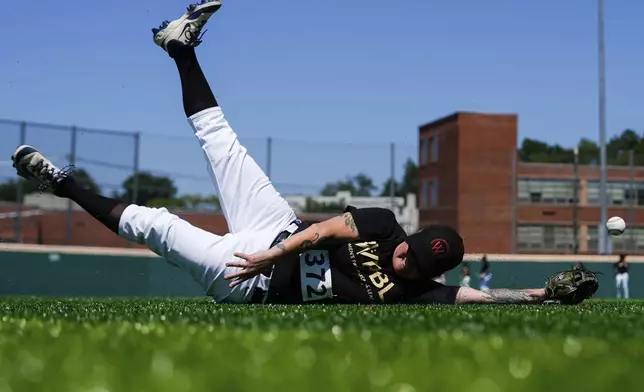 Carey Rodriguez falls while trying to catch the ball during the first day of tryouts for the Women's Professional Baseball League, Friday, Aug 22, 2025, at the Washington Nationals Youth Baseball Academy in Washington. (AP Photo/Julia Demaree Nikhinson)
