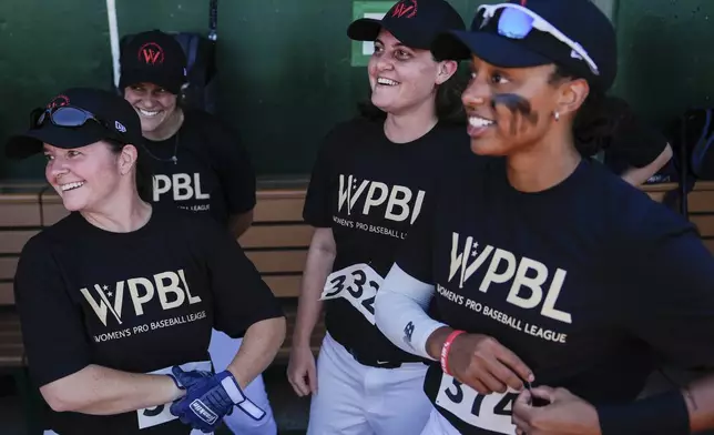 Lauren Boden, second from right, Stephanie Everett, right, and other players talk in the dugout during the first day of tryouts for the Women's Professional Baseball League, Friday, Aug 22, 2025, at the Washington Nationals Youth Baseball Academy in Washington. (AP Photo/Julia Demaree Nikhinson)