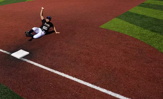Rakyung Kim slides to third base during the first day of tryouts for the Women's Professional Baseball League, Friday, Aug 22, 2025, at the Washington Nationals Youth Baseball Academy in Washington. (AP Photo/Julia Demaree Nikhinson)