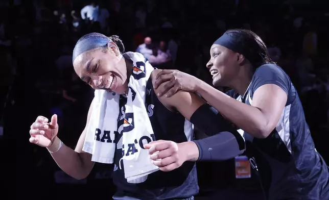 Las Vegas Aces center A'ja Wilson, left, and forward NaLyssa Smith, right, celebrate after their team defeated the Connecticut Sun in a WNBA basketball game Sunday, Aug. 10, 2025, in Las Vegas. (Steve Marcus/Las Vegas Sun via AP)