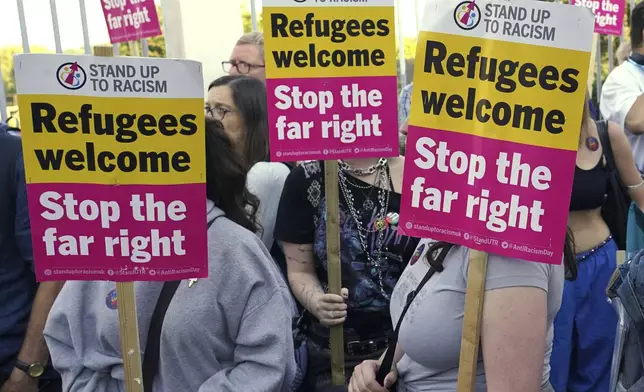 Protesters hold placards during a demonstration in Orpington near London, Friday, Aug. 22, 2025 as the dilemma of how to house asylum-seekers in Britain got more challenging for the government after a landmark court ruling this week motivated opponents to fight hotels used as accommodation.(AP Photo/Alberto Pezzali)