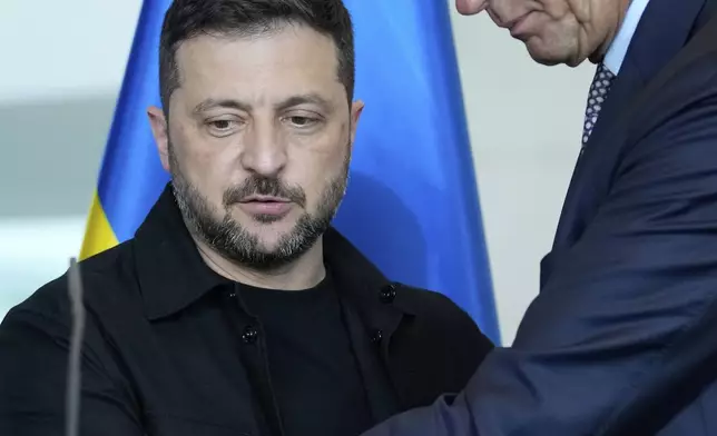 German Chancellor Friedrich Merz, right, and Ukrainian President Volodymyr Zelenskyy, left, shake hands after a joint press statement following talks with European and U.S. leaders in Berlin, Germany, Wednesday, Aug. 13, 2025. (AP Photo/Ebrahim Noroozi)