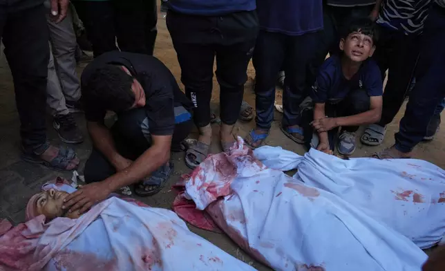 Young Palestinian Tariq Nasser, 12, right, mourns over the body of his brother Ayman Nasser, who was killed in an Israeli military strike, during his funeral outside Shifa Hospital in Gaza City, Sunday, Aug. 31, 2025. (AP Photo/Jehad Alshrafi)
