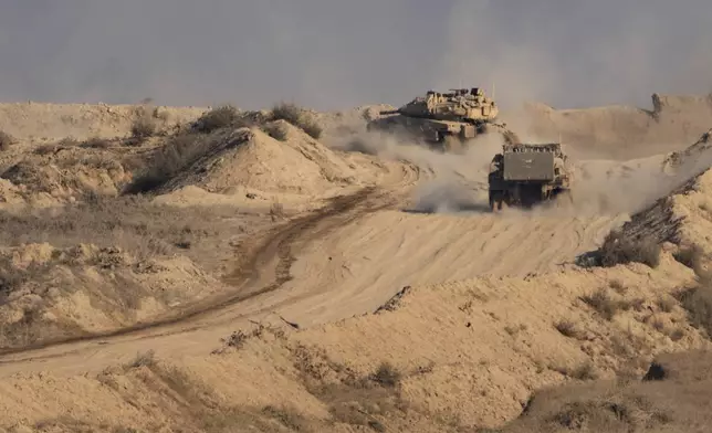 An Israeli tank and an armored personnel carrier (APC) move through an area of the Gaza Strip, as seen from southern Israel, Sunday, Aug. 31, 2025. (AP Photo/Maya Levin)