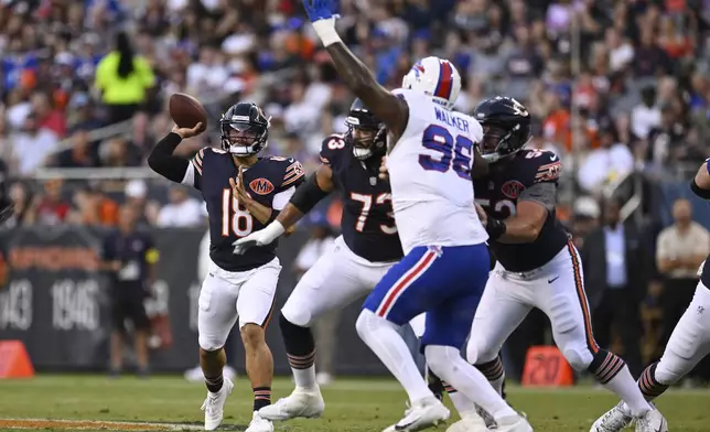 Chicago Bears quarterback Caleb Williams (18) throws a pass under pressure from Buffalo Bills defensive tackle Deone Walker (96) in the first half of a preseason NFL football game Sunday, Aug. 17, 2025, in Chicago. (AP Photo/Paul Beaty)