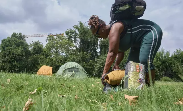 Ms. Jay, of Washington, who lost her job and is living what she calls her "Girl Scout life" while saving money by urban camping and looking for work while homeless, packs up her tent and belongings in a small park by Georgetown, Wednesday, Aug. 13, 2025, in Washington, after being warned by an aid organization that tents are being removed. "Last night was so scary," says Ms. Jay, "I don't want to be the one to wait until the last moment and then have to rush out." (AP Photo/Jacquelyn Martin)