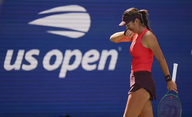 Emma Raducanu, of Great Britain, wipes sweat from her face between serves from Elena Rybakina, of Kazakhstan, during the third round of the U.S. Open tennis championships, Friday, Aug. 29, 2025, in New York. (AP Photo/Kirsty Wigglesworth)