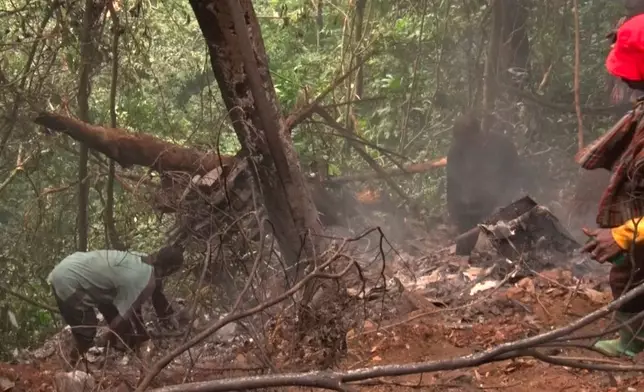In this image taken from video, people work at the site of a military helicopter crash in Sikaman near Adansi, Ashanti region, Ghana, Wednesday, Aug. 6, 2025. (AP Photo/Hafiz Tijani)
