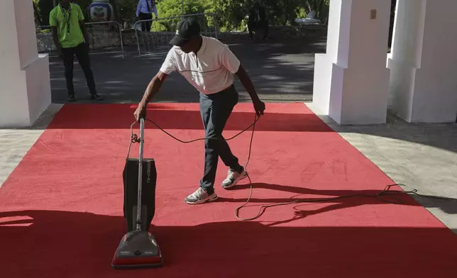 A worker cleans the red carpet for the installation ceremony of Laurent Saint-Cyr, who replaces Fritz Alphonse Jean, for the rotating presidency of the transitional presidential council in Port-au-Prince, Haiti, Thursday, Aug. 7, 2025. (AP Photo/Odelyn Joseph)