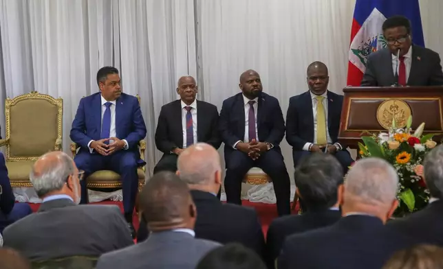 Outgoing president of the transitional council Fritz Alphonse Jean, right, speaks during a ceremony to name Laurent Saint-Cyr, center, as the new council president in Port-au-Prince, Haiti, Thursday, Aug. 7, 2025. (AP Photo/Odelyn Joseph)
