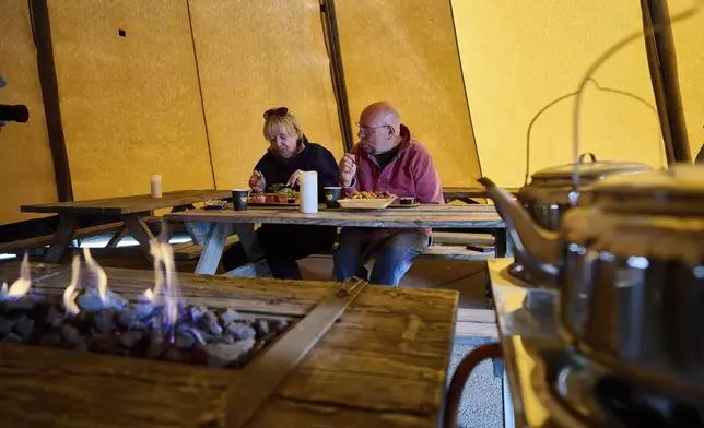 Anita and Don Haymes eat at the Stejk Street Food food truck in Kiruna, Sweden, Sunday, Aug. 17, 2025. (AP Photo/Malin Haarala)