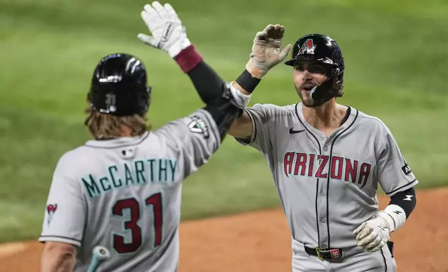 Arizona Diamondbacks' Blaze Alexander, right, and Jake McCarthy (31) celebrate after Alexander hit a solo home run in the sixth inning of a baseball game against the Texas Rangers Monday, Aug. 11, 2025, in Arlington, Texas. (AP Photo/Tony Gutierrez)