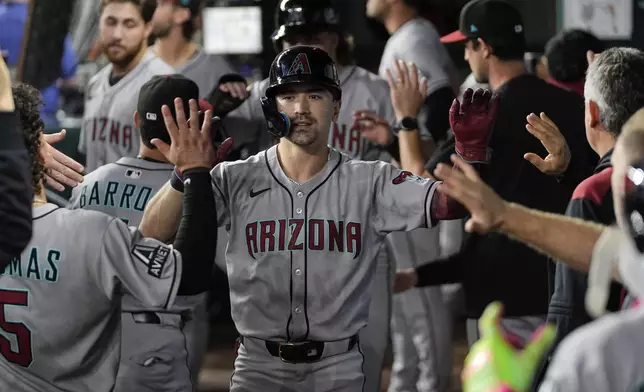 Arizona Diamondbacks' Corbin Carroll celebrates his two-run home run with the team in the third inning of a baseball game against the Texas Rangers Monday, Aug. 11, 2025, in Arlington, Texas. (AP Photo/Tony Gutierrez)