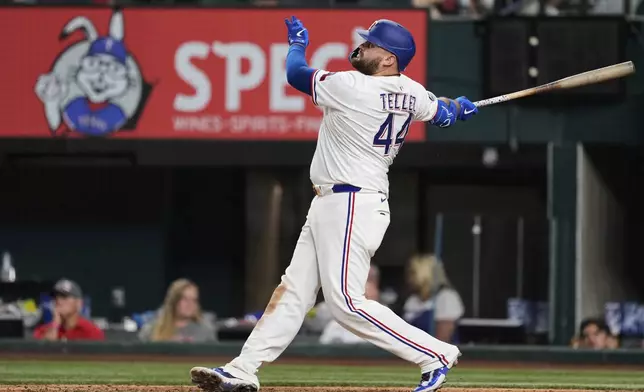 Texas Rangers' Rowdy Tellez follows through on a solo home run swing in the ninth inning of a baseball game against the Arizona Diamondbacks Monday, Aug. 11, 2025, in Arlington, Texas. (AP Photo/Tony Gutierrez)