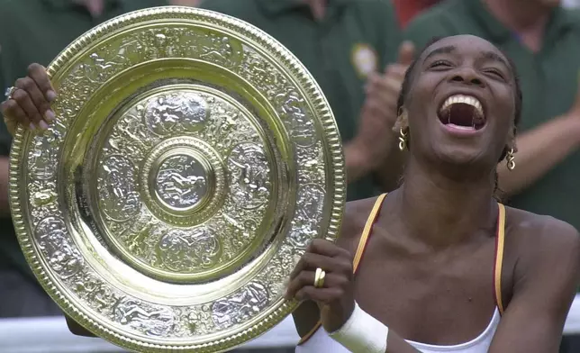 FILE - Venus Williams laughs as she holds the Women's Singles trophy on the Centre Court at Wimbledon Saturday, July 8, 2000. (AP Photo/Adam Butler, file)
