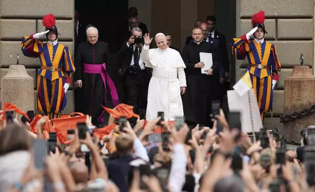 Pope Leo XIV is greeted by faithful as he arrives at the St. Thomas of Villanova Church to celebrate a mass, in Castel Gandolfo, on the outskirts of Rome, Friday, Aug.15, 2025. (AP Photo/Gregorio Borgia)
