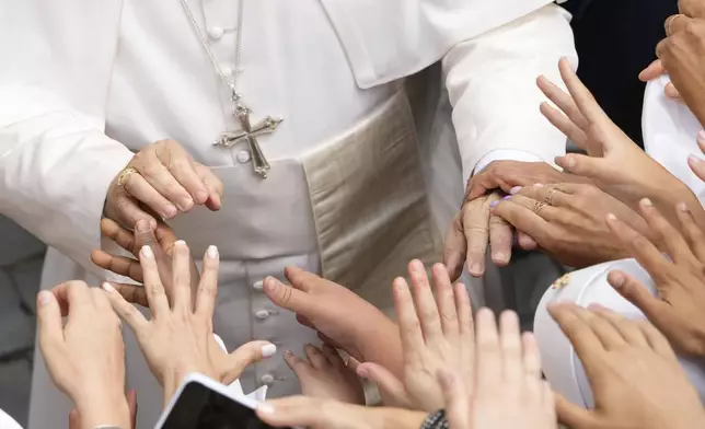 Pope Leo XIV greets faithful at the end of the Angelus prayer in Castel Gandolfo, Italy, Friday, Aug.15, 2025. (AP Photo/Gregorio Borgia)