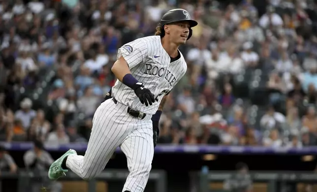 Colorado Rockies' Jordan Beck runs down the first base line on an RBI double in the third inning of a baseball game against the Arizona Diamondbacks, Saturday, Aug. 16, 2025, in Denver. (AP Photo/Geneva Heffernan)