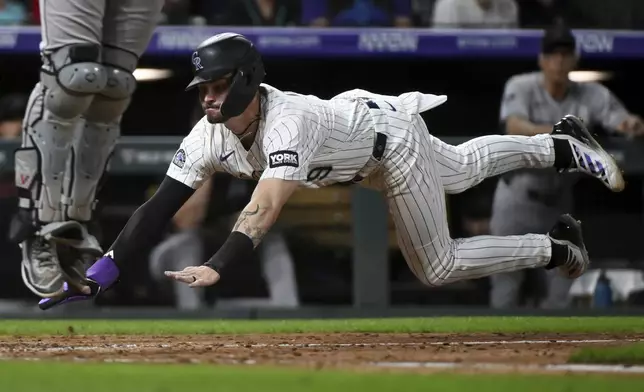 Colorado Rockies' Brenton Doyle slides safely home in the eighth inning of a baseball game against the Arizona Diamondbacks Saturday, Aug. 16, 2025, in Denver. (AP Photo/Geneva Heffernan)