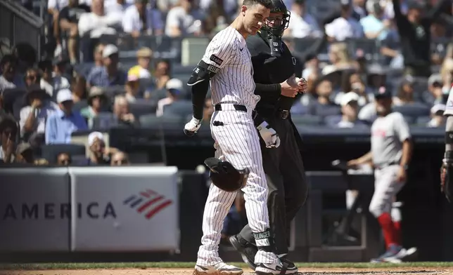New York Yankees' Cody Bellinger throws his helmet on the ground after being called out on strikes during the third inning of a baseball game against the Boston Red Sox, Saturday, Aug. 23, 2025, in New York. (AP Photo/Pamela Smith)