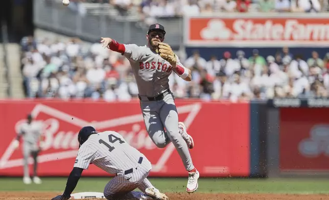New York Yankees' Amed Rosario, left, is grounded out by Boston Red Sox shortstop Trevor Story, right, during the second inning of a baseball game Saturday, Aug. 23, 2025, in New York. (AP Photo/Pamela Smith)