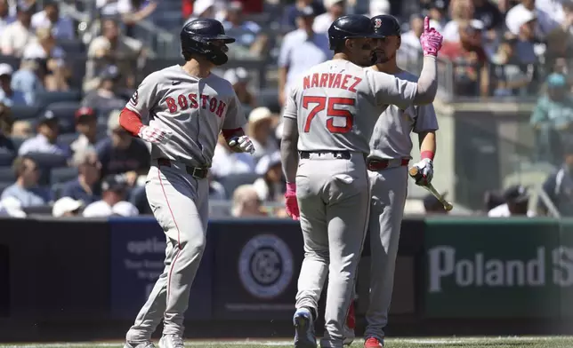 Boston Red Sox's Roman Anthony, left, and Carlos Narváez, center, react after scoring on a double hit by Trevor Story with Nathaniel Lowe, right, during the third inning of a baseball game against the New York Yankees, Saturday, Aug. 23, 2025, in New York. (AP Photo/Pamela Smith)