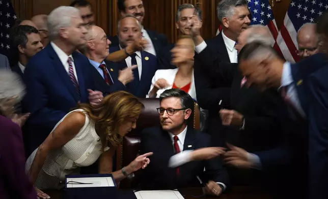 Republican Congresspeople reach to shake hands with Speaker of the House Mike Johnson, R-La. after he signed President Donald Trump's signature bill of tax breaks and spending cuts at the Capitol in Washington, July 3, 2025. (AP Photo/Julia Demaree Nikhinson)