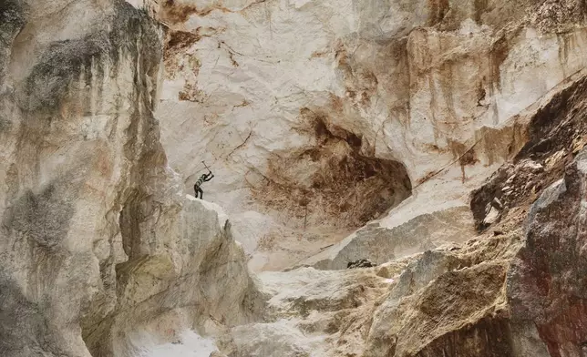 A worker pounds into rock to make gravel and sand in Kenscoff, a neighborhood of Port-au-Prince, Haiti, July 24, 2025. (AP Photo/Odelyn Joseph)