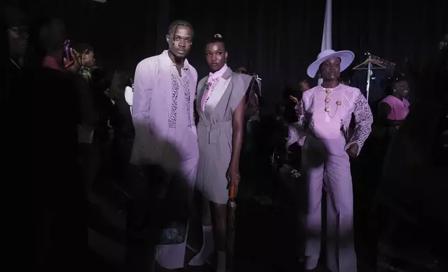 Models wear creations by designer TAI.LORE as they pose for a photograph backstage before Fashions Finest Africa Week in Lagos, Nigeria, July 6, 2025. (AP Photo/Sunday Alamba)