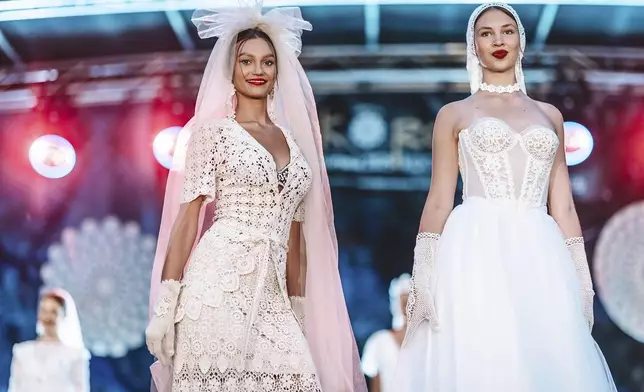 Models showcase handmade wedding dresses crafted from traditional lace at a fashion show in the village of Koniakow, in Poland's Beskid Mountains, Saturday, Aug. 16, 2025. (AP Photo/Daniel Franek)