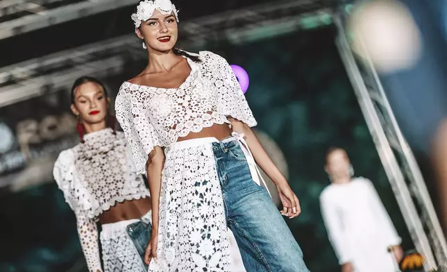 Models present hand-made lace outfits during a fashion show in the village of Koniakow, in Poland’s Beskid Mountains, Saturday, Aug. 16, 2025. (AP Photo/Daniel Franek)