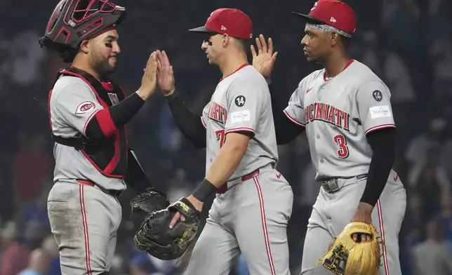 Cincinnati Reds catcher Jose Trevino, left, celebrates with Spencer Steer, center, and Ke'Bryan Hayes after the Reds defeated the Chicago Cubs in a baseball game in Chicago, Tuesday, Aug. 5, 2025. (AP Photo/Nam Y. Huh)