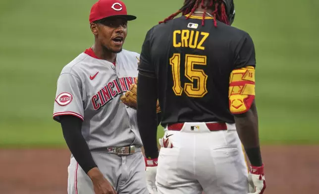 Cincinnati Reds third base Ke'Bryan Hayes, left, visits with Pittsburgh Pirates' Oneil Cruz (15) who stands on third base during the first inning of a baseball game in Pittsburgh, Thursday, Aug. 7, 2025. (AP Photo/Gene J. Puskar)