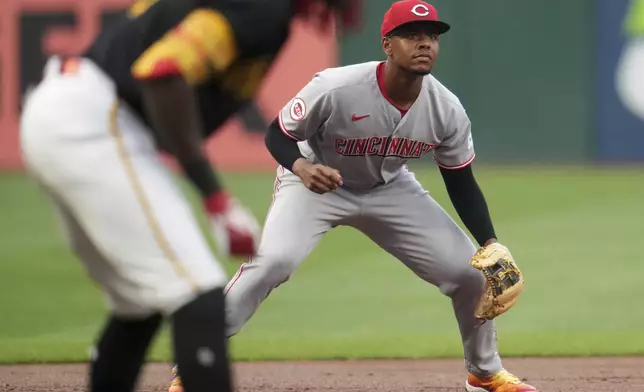 Cincinnati Reds' Ke'Bryan Hayes, right, gets set for a pitch as Pittsburgh Pirates' Oneil Cruz, left, leads off third base during the first inning of a baseball game in Pittsburgh, Thursday, Aug. 7, 2025. (AP Photo/Gene J. Puskar)