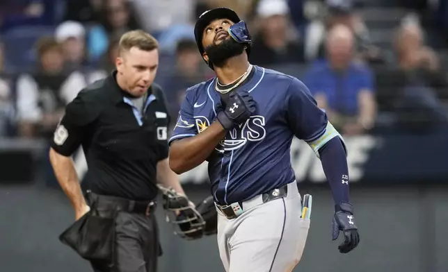 Tampa Bay Rays' Junior Caminero gestures as he crosses home plate with a home run in the fifth inning of a baseball game against the Cleveland Guardians in Cleveland, Monday, Aug. 25, 2025. (AP Photo/Sue Ogrocki)